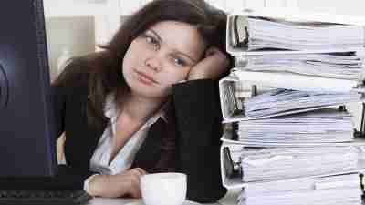 A woman next to binders filled with her child's IEP, which has many problems