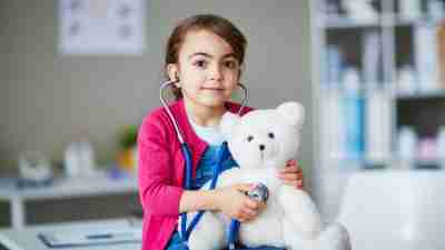 A gAn ADHD girl with SPD examines her teddy bear.irl with SPD examines her teddy bear.