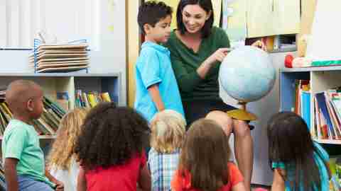 A teacher giving an attention grabbing presentation, a good strategy to improve classroom behavior.