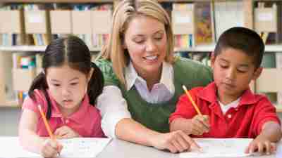 Teacher helping two students at the beginning of the new school year