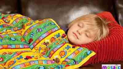 A girl with ADHD sleeps under a weighted blanket she received as a gift.