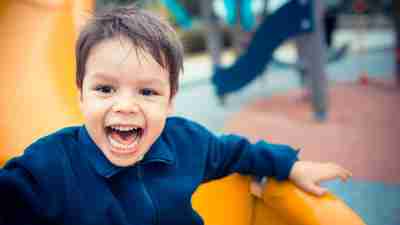 A preschooler with ADHD playing on the slide at the playground