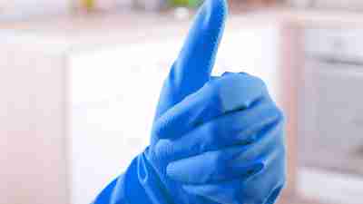 An adult with ADHD gives a thumbs up after washing the dishes and cleaning the house