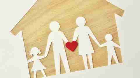 A paper family on a wooden house, holding a heart to represent love, support, and ADHD help