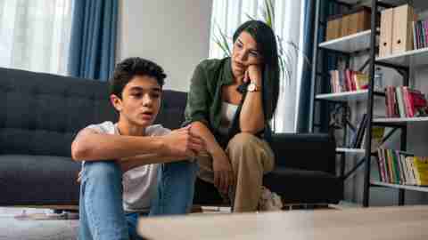 Mother and son sitting after quarrel at home