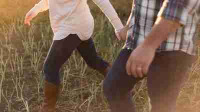 A wife holds her husband's hand as they walk. She is his support network as an adult with ADD.