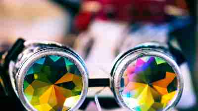 Rainbow kaleidoscope glasses sitting on a surface.