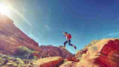 Man with ADHD jumps across boulders showing his spontaneity.