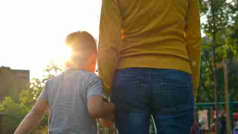 ADHD child holds his mother's hand as they go to the playground