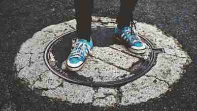 High school student with ADHD standing on manhole cover