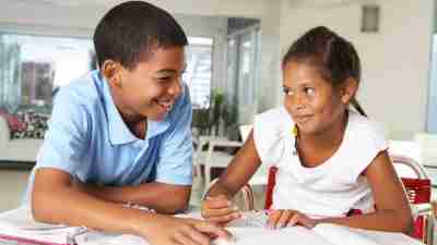 Two siblings with ADHD, working together to get their homework done faster.