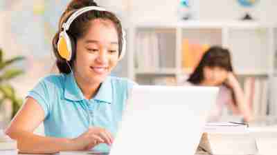 A young girl with ADHD using assistive technology on her computer at school