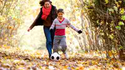 A mother and daughter playing soccer together, demonstrating how physical activity and one-on-one attention can serve as natural remedies for ADHD