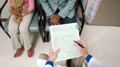 A doctor filling out a questionnaire for a patient